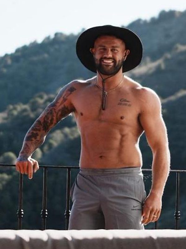 James after coaching, on a terrace in the hills, wearing a hat.